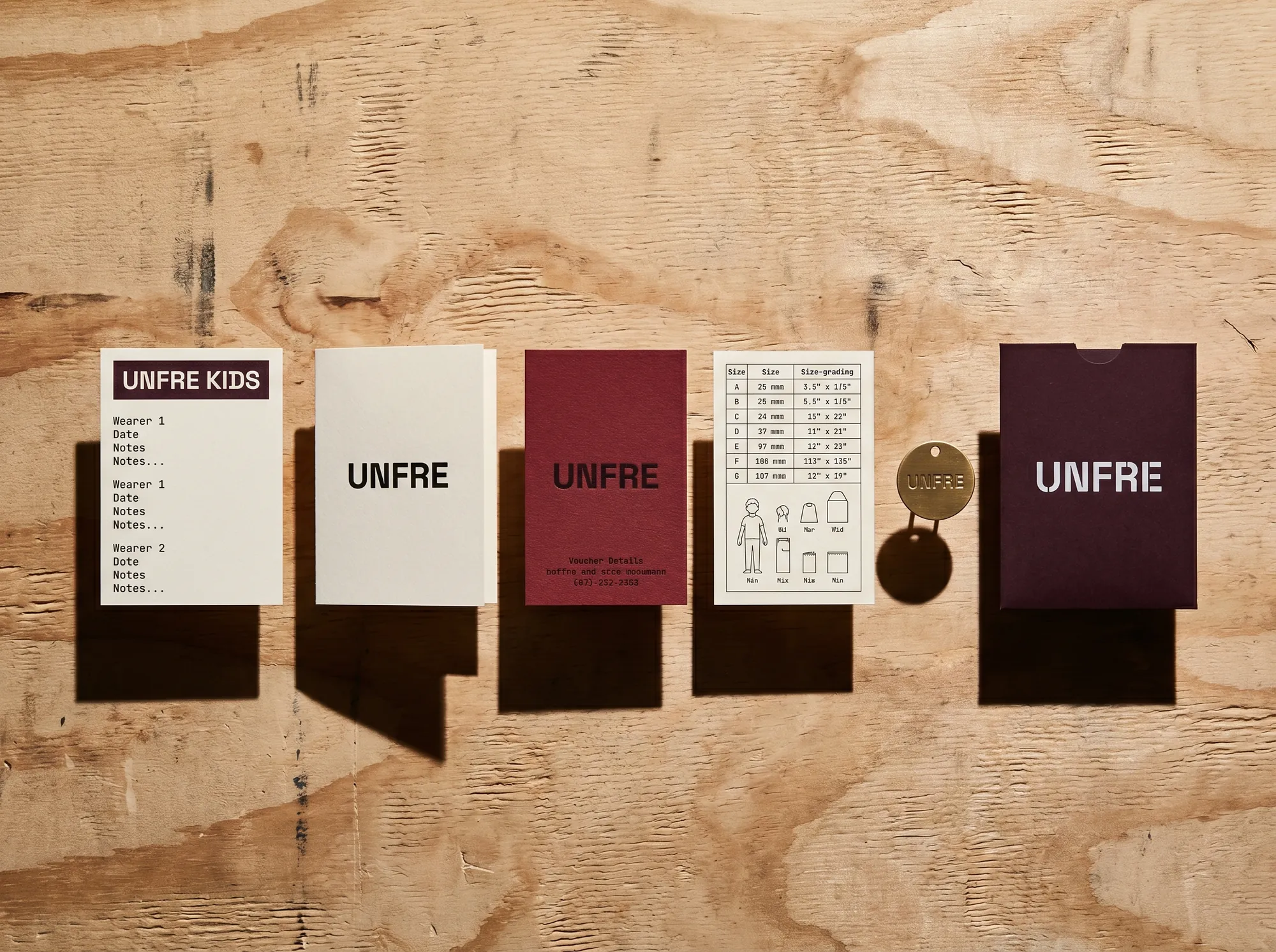 Unfre Kids Log (Children's Built-To-Last Apparel) — A boxed hand-down log card set — wearer history, voucher card, working size-grading reference, customer-number tag.